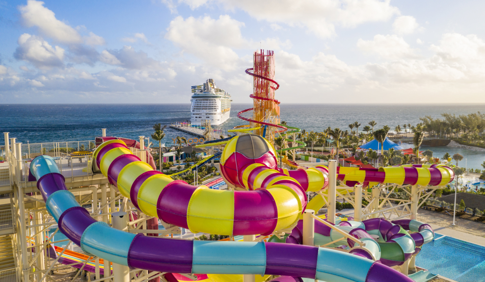 colorful water slides and water slide tower with cruise ship in the background