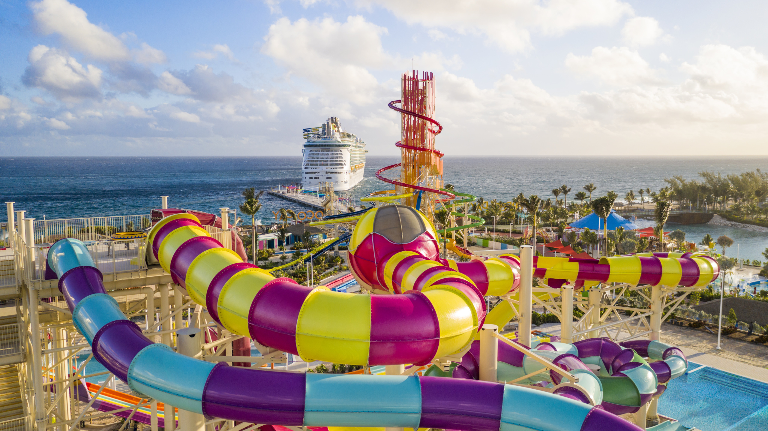 colorful water slides and water slide tower with cruise ship in the background
