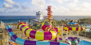 colorful water slides and water slide tower with cruise ship in the background