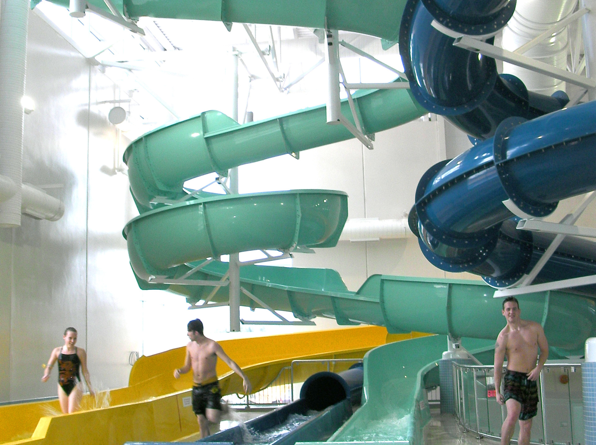 Three young people have just finished their ride on the spinning slide