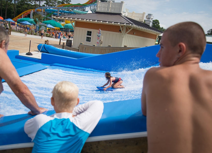 Kid having fun surfing at the best FlowRider Double by WhiteWater West at Waterbom Bali Kuta Bali