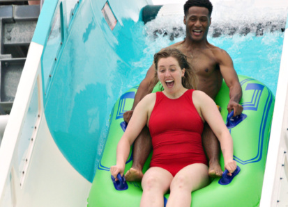 Man and woman sliding down water coaster