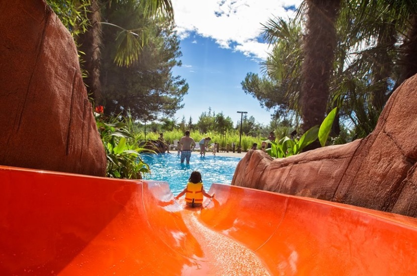 Child going down a water slide in a scenic water park