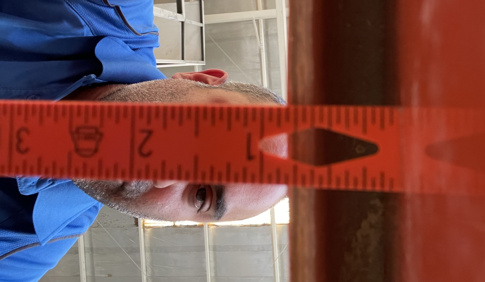 Man measuring a gap for water ride maintenance