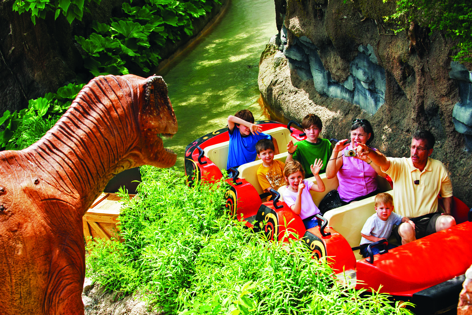 People inside a water transportation system boat looking at a dinosaur