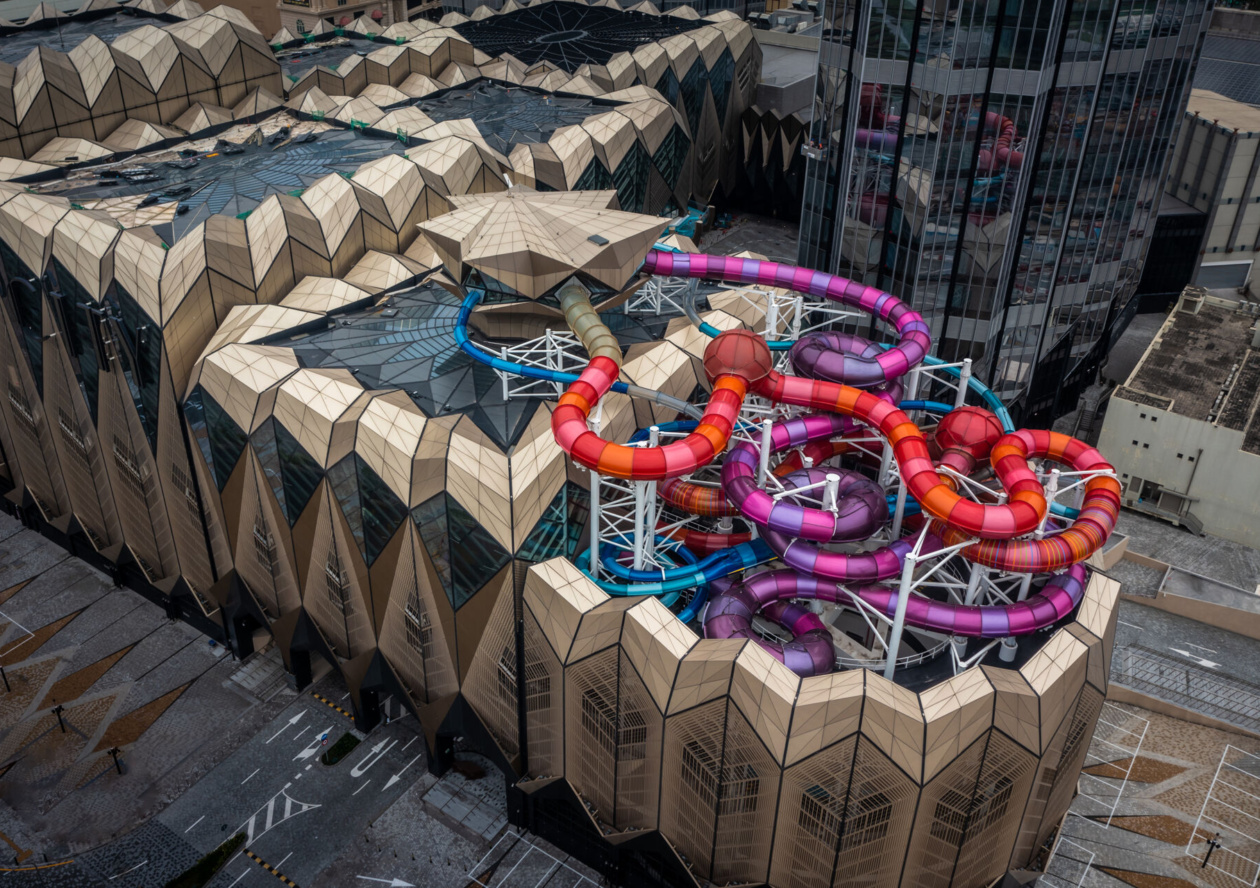 Facade of an indoor water park with protruding metallic colored water slides