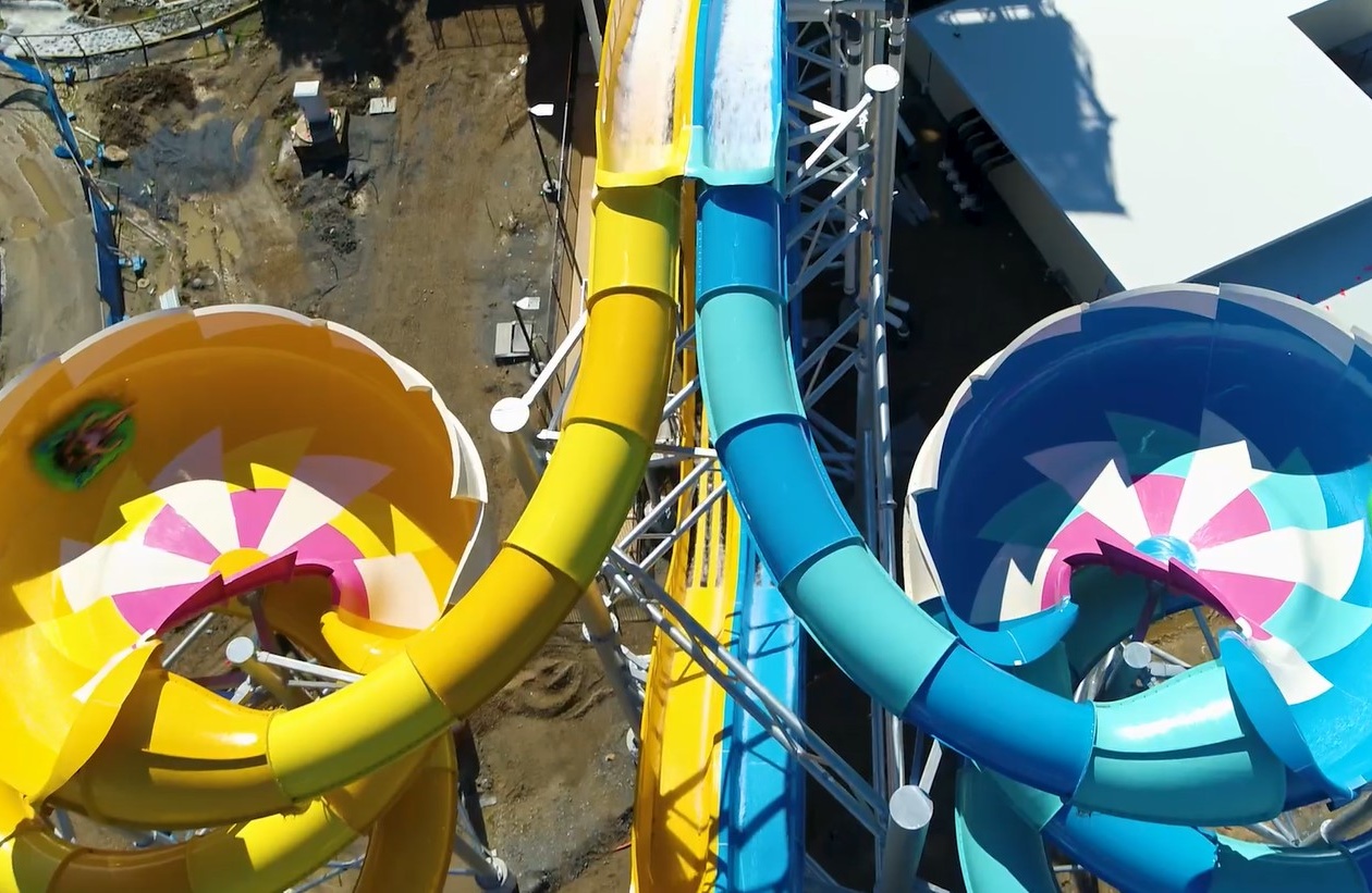 Two mirroring water slides, one yellow, one blue