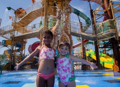 Two girls in front of an animal-themed aquatic play structure