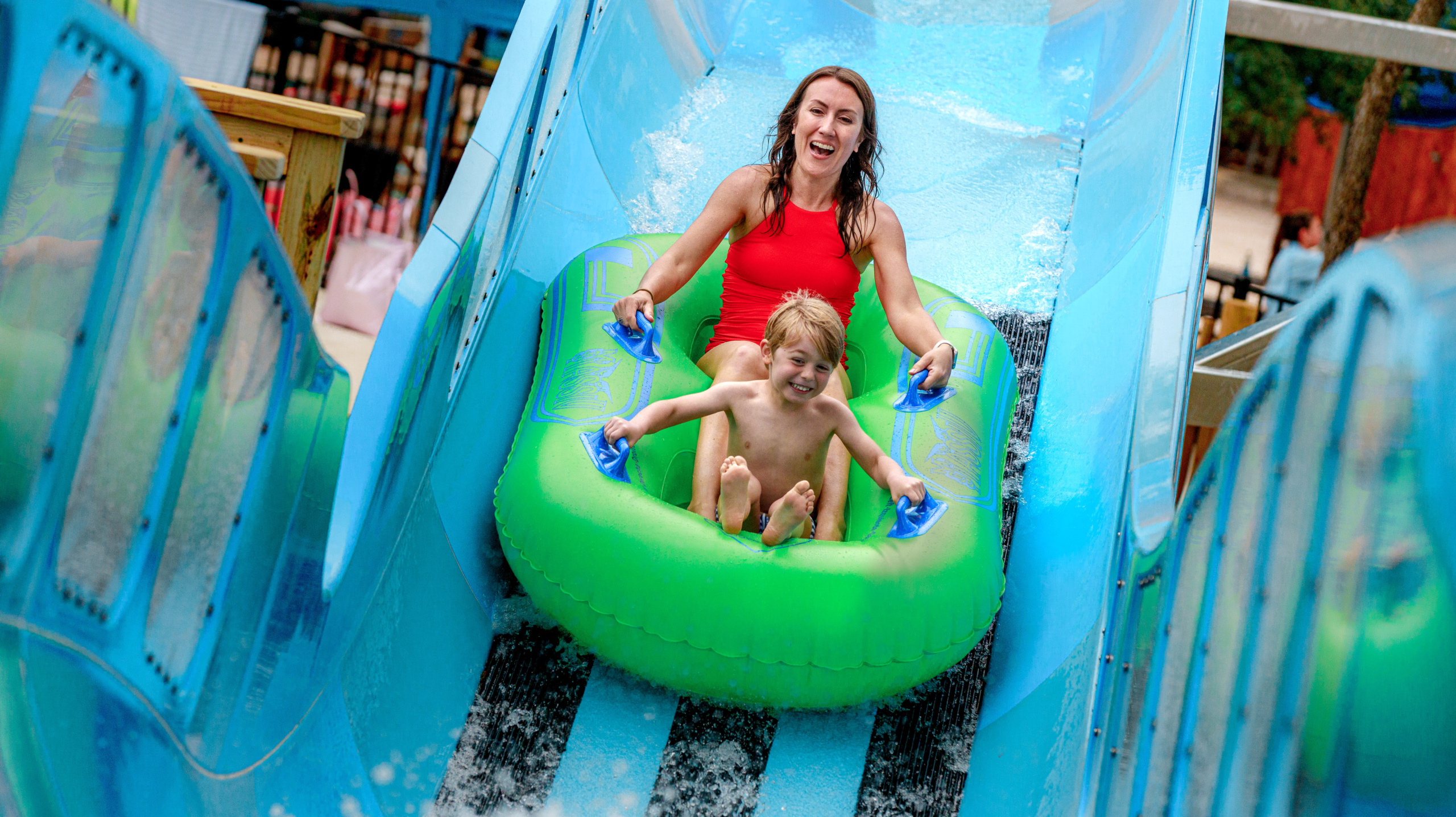 Small child and an adult in an inner tube on a water coaster